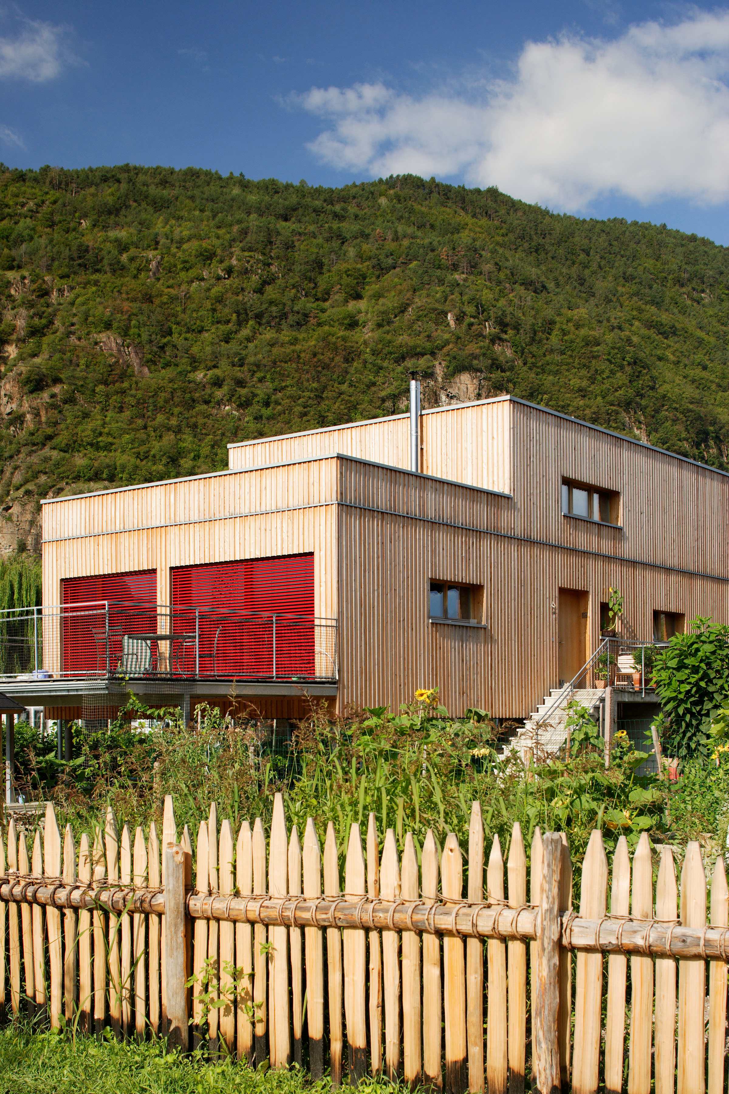 Ein von Planus realisiertes Haus in Holz100-Bauweise hinter einem Holzzaun.